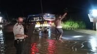 Kapolsek Panimbang Amankan Arus Jalan Dari Material Kayu Pasca Banjir